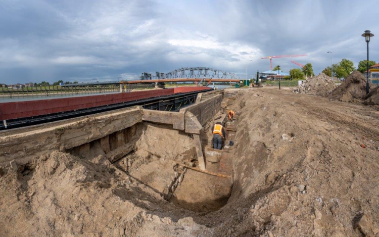 De archeologen zijn aan het werk in een afgegraven deel achter de kade